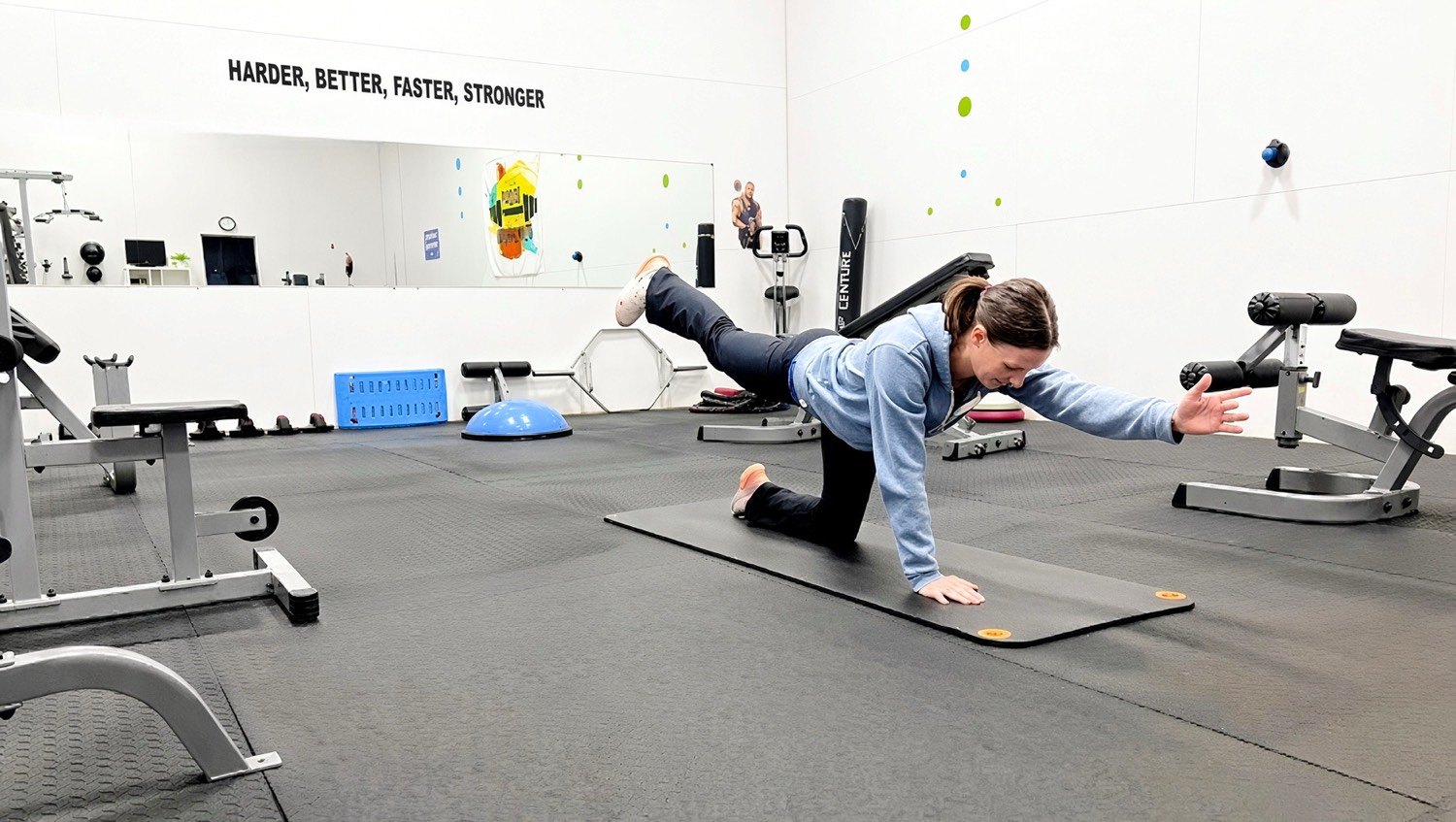 A client holding a bird-dog on a mat in the Techny Fitness studio